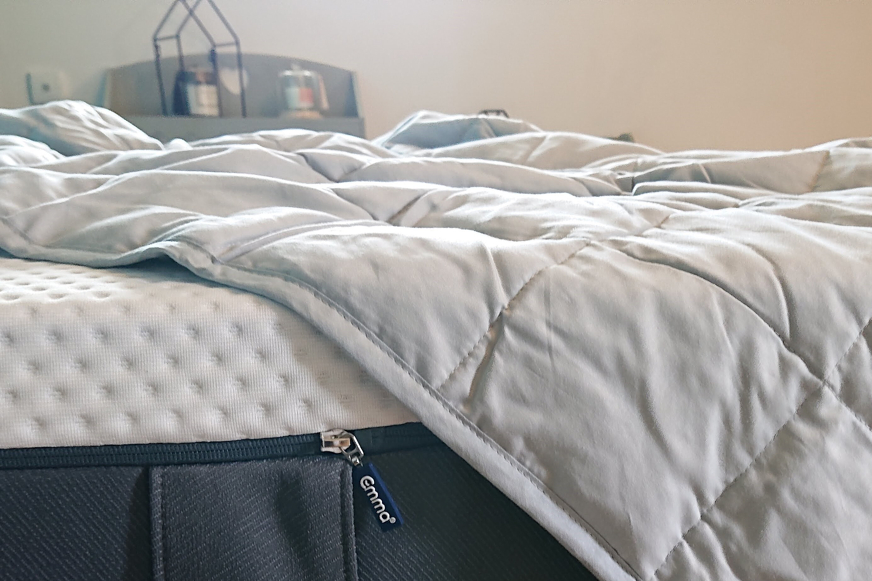 Cobertor pesado com uma ponta dobrada sobre a borda da cama